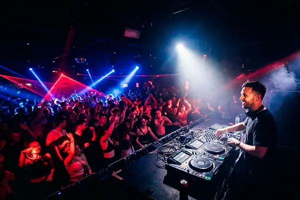 Leje af jukebox til fest – priser, levering og alt du skal vide 9 DJ spiller for dansende publikum med blåt og rødt scenelys