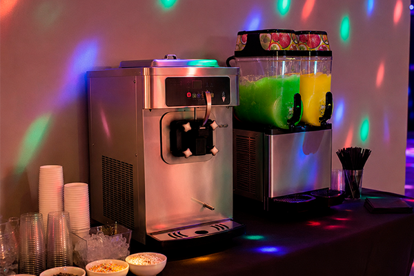 Softice maskine og slush ice maskine opstillet side om side til fest med diskolys